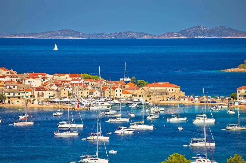 Charter yachts moored in front of Island Primosten